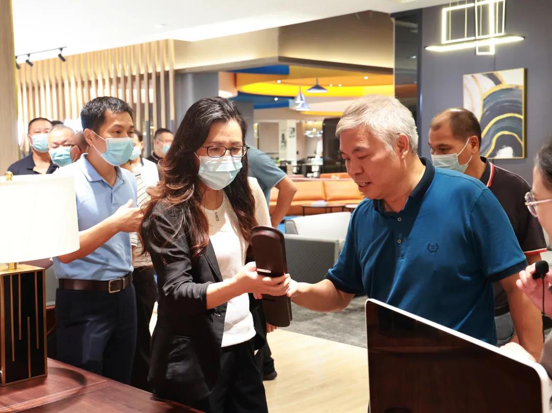 迪歐家具集團董事副總裁黃云林為調研組展示實木辦公家具產品