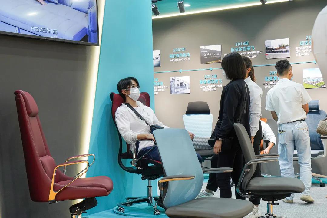 圖丨客商們在迪歐展位現場體驗辦公坐具的產品性能